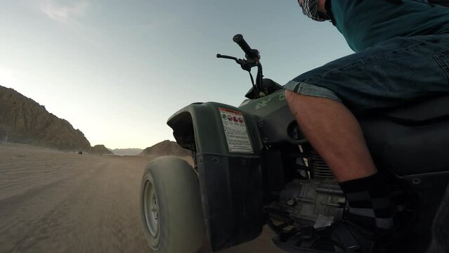Tourist vacationer rides quad bike on safari in Egyptian desert. Travel and tourist entertainment 