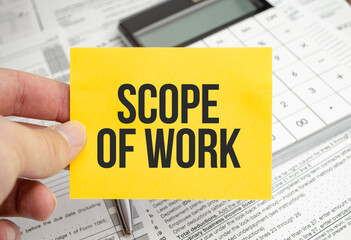 Scope Of Work on yellow paper sheet with calculator and tax forms