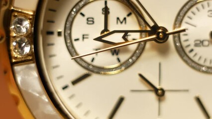 Clock hands in motion on the dial clock face of a gilded gold plated mechanical quartz glamorous chronometer watch close-up macro. Running of time and life 