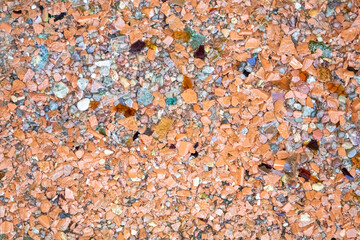 The sand is made of white, black and orange small pebbles and pieces of shells