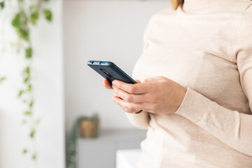 Close up view of young woman hands using mobile phone at business office