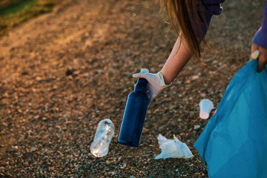 Girl recycling garbage with gloves and a plastic bag