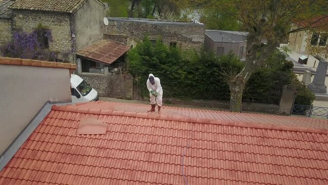 Professional wearing uniform, using equipment for Painting roof tiles