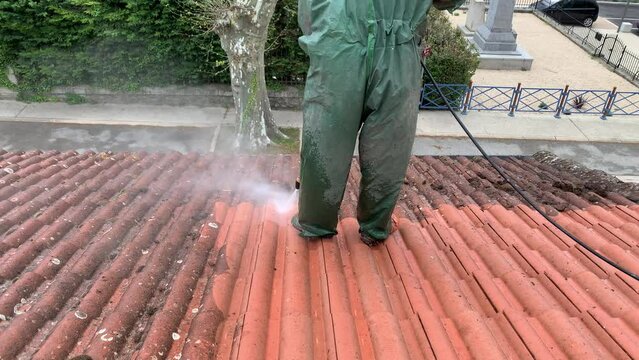 Professional wearing uniform, equipment for cleaning roof tiles