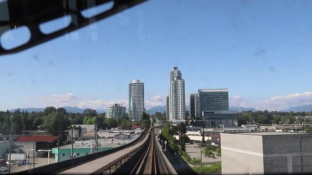 Metro Vancouver Sky Train travels along the rails on the bridge. View from the inside through the dirty glass of the car