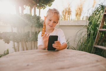 Little girl using smartphone, laughing.