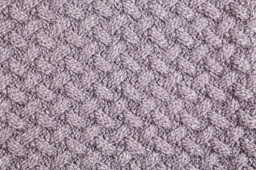 Grey knitted wool background. The texture of a woolen thing with a pattern