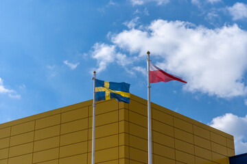 Polish and Swedish flags flying on a high mast