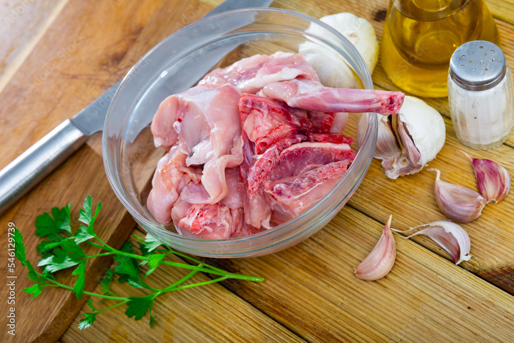 Wall mural Raw rabbit meat with spices and herbs in transparent plate. Healthy food