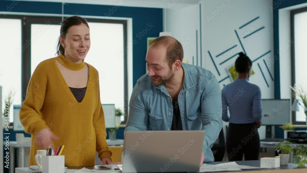 Poster smiling coworkers in office looking at laptop screen comparing business analytics with sales charts 