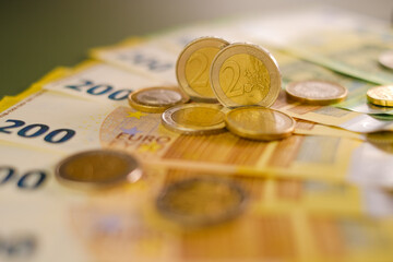  two euro coins and Two hundred euro banknotes .Expenses and incomes in European countries. Finance...