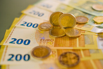  euro coins and banknotes on a green background.Expenses and incomes in European countries. Finance...