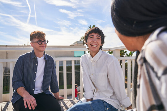friends listening and laughing on beachside patio