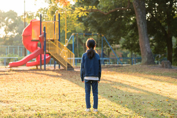 秋の公園で遊んでいる小学生の女の子の姿