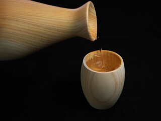 Tokyo,Japan - November 15, 2022: Wooden hinoki sake bottle, tokkuri, and wooden cup, Guinomi or...