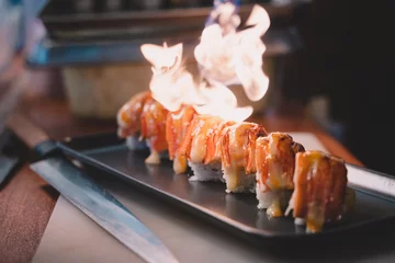  sushi salmon burn is a meal fish. chef is cooking by fire burn. sushi is a street food of japan and new business in the world. © Atthapon