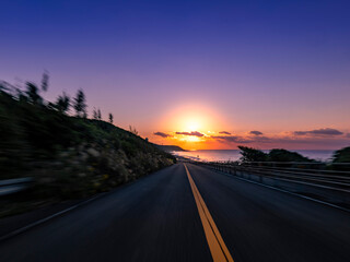 Fototapeta premium POV shot of driving through the woods and up a slope along the coast at dawn 