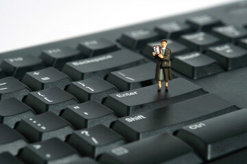 Miniature people toy figure photography. A woman holding photo frame standing above keyboard, searching missing person because of war conflict