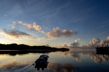 sun rise scene in Palau. The morning sun light reflects on the sea, clouds with orange color.