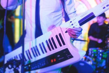 Concert view of a keytar synthesizer player with vocalist and musical jazz rock band orchestra...