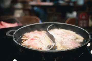 Boiling meat in Japanese shabu shabu sukiyaki hot pot in Japanese restaurant