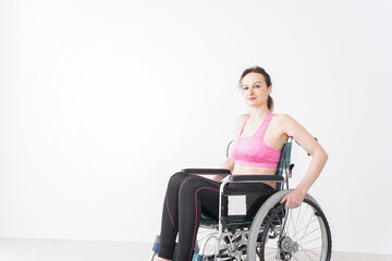 Obraz na płótnie Canvas スポーツウェアを着て車椅子に乗る外国人の女性