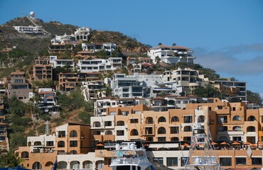 Fototapeta na wymiar The view of luxury waterfront homes on top of the hill near Cabo San Lucas, Mexico
