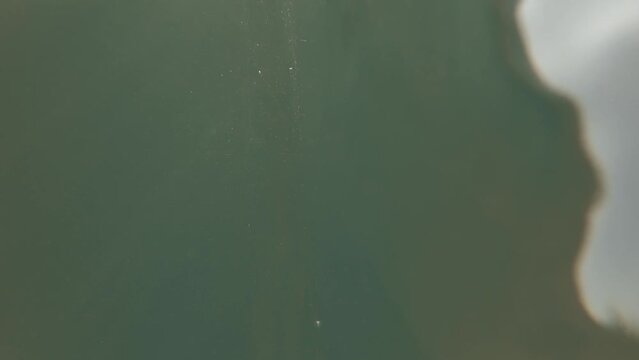 Underwater cinematic beach shot with split visuals with camera half dipped in water | vertical shot