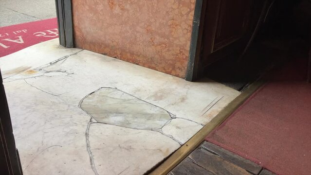 Waitress step on the ancient marble  floor on the entrance of historical Caffà Al Bicerin in Turin