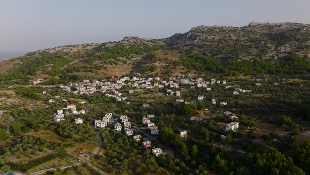 Quaint Pilonas village amongst olive groves in Pilonas, Greece; aerial