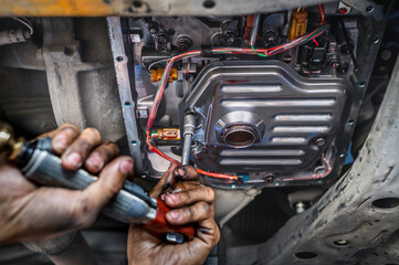 Auto mechanic installing an automatic transmission filter.	 - obrazy, fototapety, plakaty
