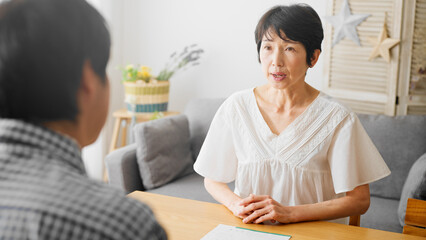 言い争いをするミドル女性とミドル男性の夫婦　熟年離婚イメージ	
