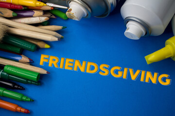 Overhead shot of school supplies with Friendsgiving text. Brushes, pencils, artistic tools. Art And Craft Work Tools.