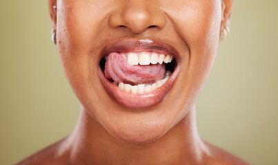 Tongue, teeth and african woman in closeup with lick, smile or happy for dental wellness in studio....