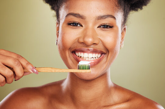 Brushing teeth, black woman beauty and dental wellness, healthy lifestyle and cleaning cosmetics on studio background. Happy african model face portrait, toothpaste on toothbrush and mouth smile