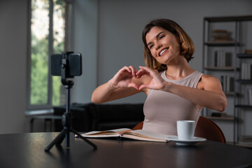 Fototapeta premium Shiny businesswoman in casual wear making video blog using smartphone