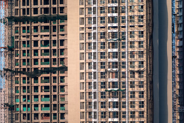 Fototapeta premium Safety nets and scaffolding on a tall high rise building under construction in the city of Mumbai.