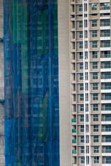 Fototapeta premium Safety nets and scaffolding on a tall high rise building under construction in the city of Mumbai.
