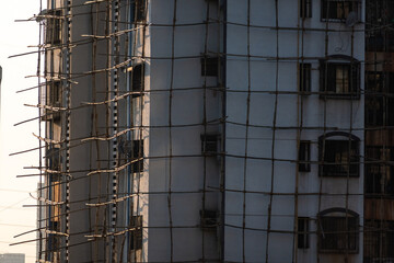 The exterior facade of a high rise apartment building covered in scaffolding for repair in the suburb of Kandivali.
