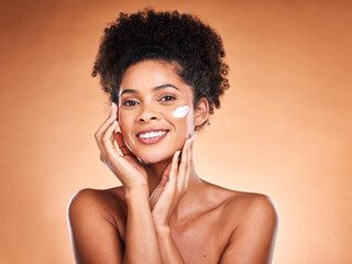 Skincare, beauty and black woman with face cream in studio for moisturizing on brown background....