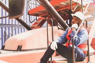 African American male engineer worker sits alone bored depressed  stressed out on a container...