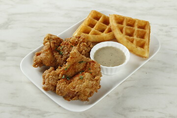 Breakfast fried chicken platter with waffles, gravy and syrup