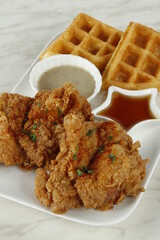 Breakfast fried chicken platter with waffles, gravy and syrup