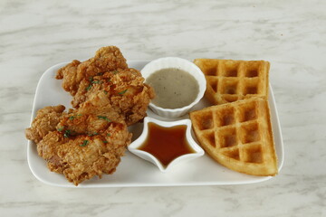 Breakfast fried chicken platter with waffles, gravy and syrup