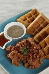 Single piece fried chicken breakfast with waffles, gravy and syrup