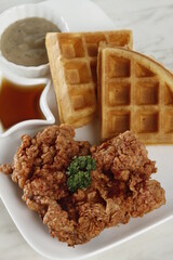 Single piece fried chicken breakfast with waffles, gravy and syrup