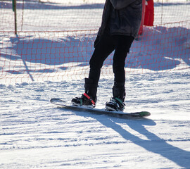 A man slides down the mountain on a snowboard in the snow.