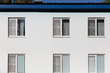 Fototapeta na wymiar Windows in a white multi-storey building
