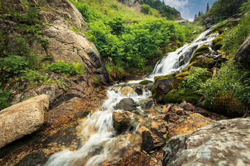 Fototapeta na wymiar Famous tourist hiking route in the mountains of Almaty - Qimasar Waterfall in the Kimasar Gorge.