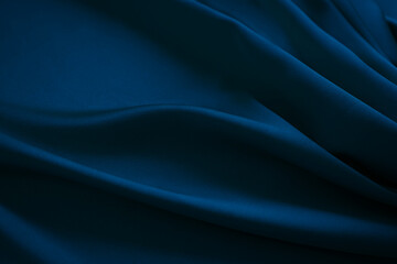 Dark blue silk satin. Soft folds.Navy blue fabric. Luxury background for design. Wavy lines. Beautiful. Elegant. Birthday, Christmas, New Year.